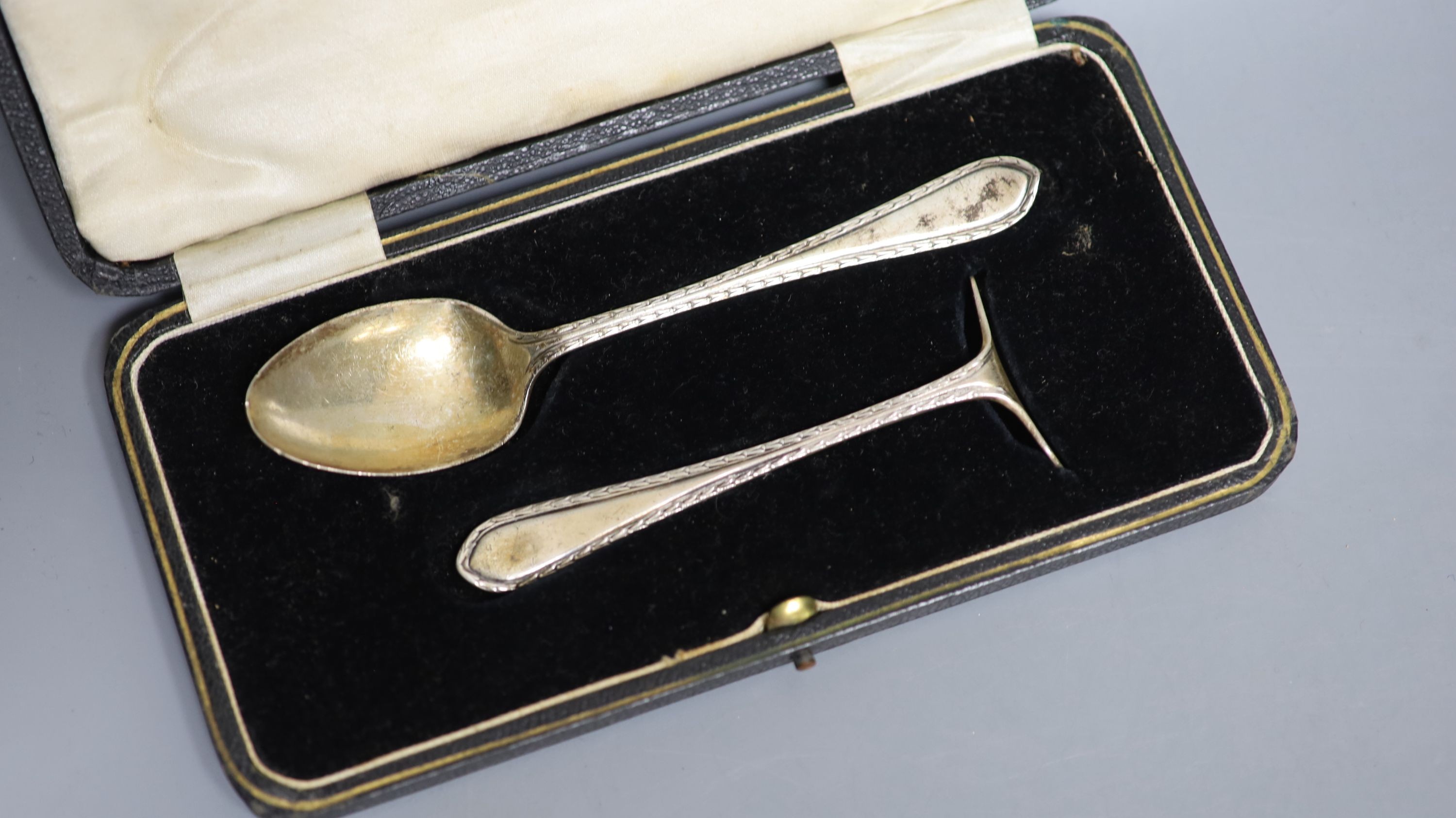 A cased set of six silver bean end coffee spoons, a cased silver spoon and pusher and a cased silver handled shoe horn and button hook.